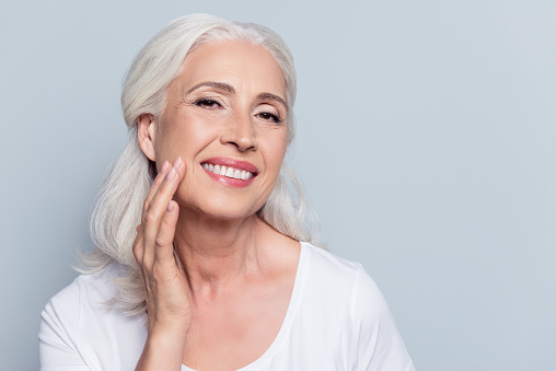 A woman with dental implants smiling at Greashaber Dentistry in Ann Arbor, MI.